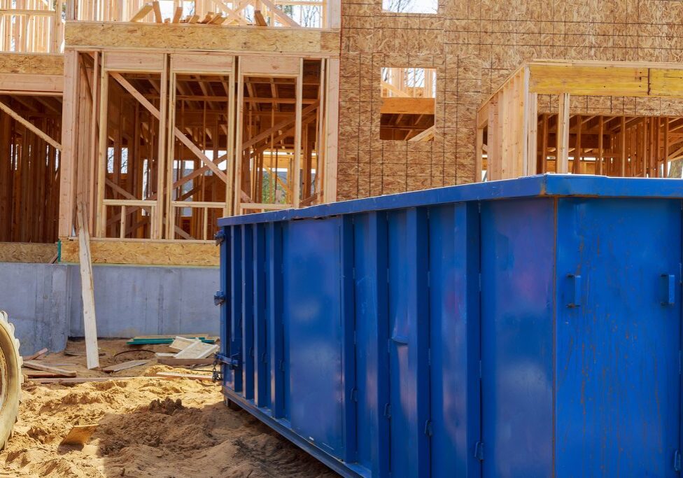 Construction site a rubbish removal container on house underneath an industrial building is used for waste disposal